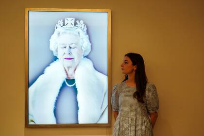 Un miembro del personal posa junto a la "Ligereza del ser" de Chris Levine, como parte de una exhibición en Sotheby's, en Londres, el viernes 27 de mayo de 2022. La exhibición se presenta antes del Jubileo de Platino de la Reina Isabel II de Gran Bretaña que marca el 70 año en el trono. (AP Photo/Alberto Pezzali)