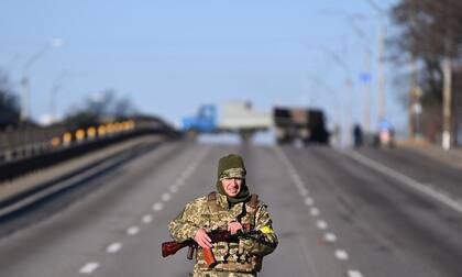 Un miembro del servicio ucraniano patrulla una autopista vacía en el lado oeste de la capital ucraniana de Kiev en la mañana del 26 de febrero de 2022