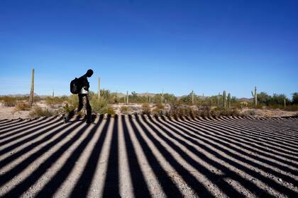 Un migrante cerca de la frontera entre Estados Unidos y México, cerca de Lukeville, Arizona, el 15 de diciembre de 2023 (Foto AP /Gregory Bull)