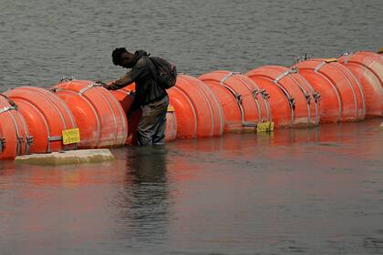 Un migrante colombiano frente la barrera flotante de boyas mientras trata de cruzar el río Bravo (Grande) de México a Estados Unidos