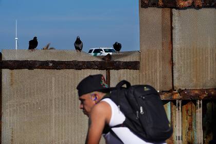 Un migrante espera por su oportunidad para cruzar la frontera desde  Tijuana, México (Archivo)
