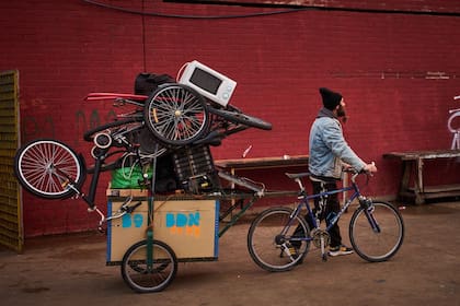 Un migrante lleva sus pertenencias en un edificio escolar abandonado donde vivían cientos de migrantes, en su mayoría indocumentados, en Badalona, cerca de Barcelona