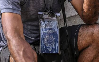 Un migrante protege su pasaporte con plástico en el campamento de Lajas Blancas, al salir de la selva del Darién en Panamá.