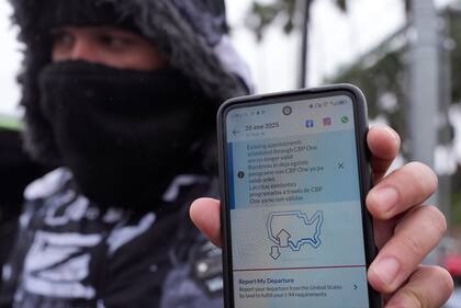 Un migrante que solicita asilo muestra la app CBP One mostrando su cita cancelada