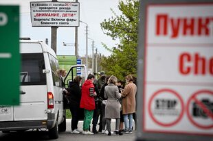 Un militar de Transnistria controla a los pasajeros de una furgoneta que entra en la autoproclamada "República Moldava de Transnistria" en el punto fronterizo de Varnita con Moldavia el 28 de abril de 2022.