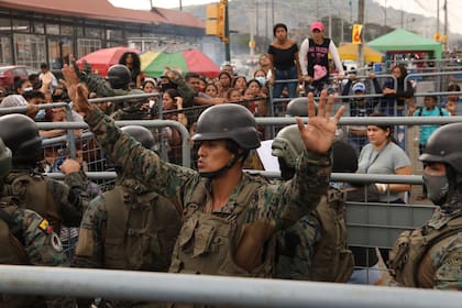 Un militar pide calma a los amigos y familiares de presos que buscaban información sobre sus seres queridos tras los enfrentamientos con muertos en la Penitenciaría del Litoral de Guayaquil, Ecuador, el martes 25 de julio de 2023.