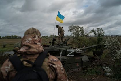 Un militar ucraniano camina sobre un tanque ruso destruido cerca de la frontera con Rusia, en Kharkiv, Ucrania, el 19 de septiembre de 2022. 