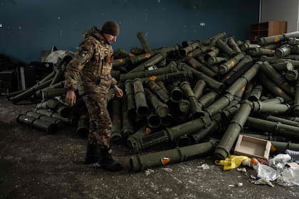 Un militar ucraniano cerca de una pila de contenedores vacíos de proyectiles de mortero en Bakhmut el 15 de febrero de 2023, en medio de la invasión rusa de Ucrania.