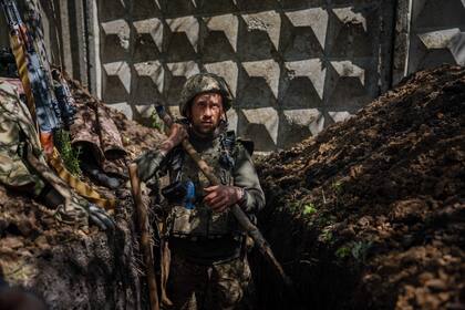 Un militar ucraniano del Servicio Estatal de Guardia Fronteriza cava una trinchera en Chasiv Yar, cerca de la ciudad de primera línea de Bakhmut, región de Donetsk (Foto de Dimitar DILKOFF / AFP)