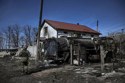 Un militar ucraniano pasa por delante de un vehículo ruso destruido en el pueblo de Mala Rogan, al este de Kharkiv, después de que las tropas ucranianas retomaran el pueblo el 28 de marzo de 2022.