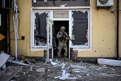 Un militar ucraniano sale de un edificio dañado después de un bombardeo en Kiev, el 11 de marzo de 2022