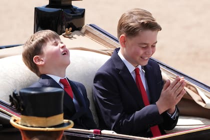 Un momento de complicidad y risas entre los hermanos George y Louis en la carroza, durante el desfile. Los dos hijos varones de William y Kate lucieron trajes azules, camisas blancas y corbatas rojas, los mismos colores de la bandera de Reino Unido.