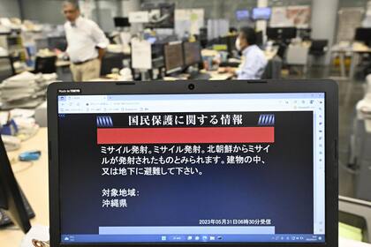 Un monitor muestra la advertencia del gobierno japonés en Okinawa. (Kyodo News via AP)