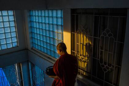 Un monje budista saliendo del nuevo monasterio Masoeyein para recolectar limosnas, en Mandalay, Birmania
