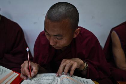 Un monje durante una clase de escritura en el Colegio Budista Tibetano