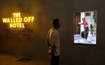 Un mono es el botones que espera a los huéspedes en el hotel The Walled Off, intervenido por Banksy y otros artistas