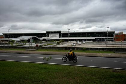 Un motociclista circula frente al aeropuerto internacional Eduardo Gomes, en Manaos
