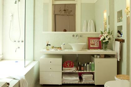 Un mueble de melamina enchapada sostiene la bacha. El espejo tiene el marco laquedo para una combinación perfecta.