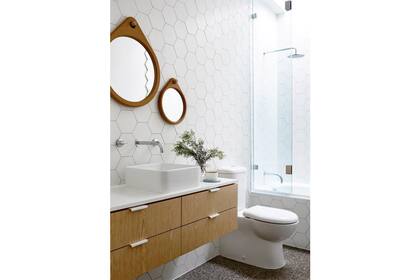 Un mueble flotante con grandes cajones brinda lugar para guardar objetos y lograr orden y prolijidad en este baño moderno