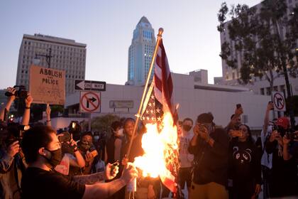 Los manifestantes quemaron una bandera estadounidense en medio de los enfrentamientos con la policía.