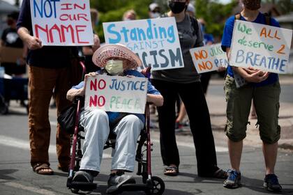 Un hombre de 87 años sostiene un cartel durante las protestas