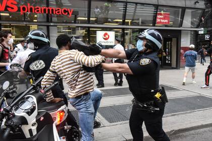 Un policía golpea a un manifestante negro durante los enfrentamientos