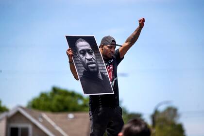 Un hombre sostiene una foto de George Floyd durante las protestas en Minneapolis.