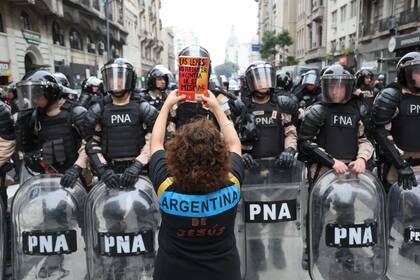 Un mujer enfrenta a la policía con un libro en sus manos