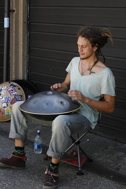 Un músico callejero toca el hang drum
