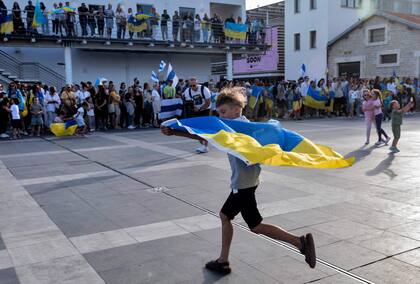 Un niño corre con una bandera nacional ucraniana durante una manifestación en solidaridad con Ucrania en la ciudad portuaria de Limassol, al sur de Chipre, mientras los europeos conmemoran la victoria aliada contra la Alemania nazi y el fin de la Segunda Guerra Mundial en Europa (Día de la Victoria), el 8 de mayo de 2022.