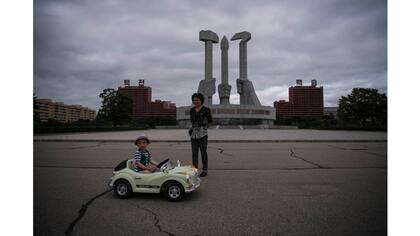 Un niño junto a su madre juega frente al Monumento a la Fundación del Partido de los Trabajadores de Corea, en Pyongyang