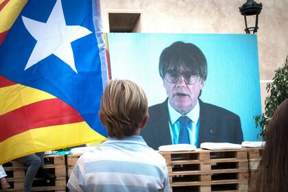 Un niño observa la intervención telemática de Puigdemont en el mitin central del partido JxCAT, a 16 de julio de 2023, en en Amer, Girona, Catalunya (España). (Glòria Sánchez - Europa Press)