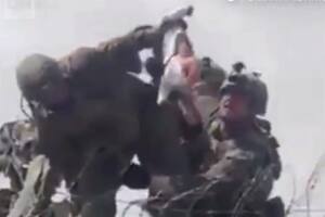 Un niño pequeño es entregado sobre el muro del aeropuerto de Kabul a las tropas estadounidenses.