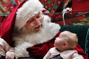 Un niño quiso llamar la atención de su madre mientras posaba con Papá Noel, pero su pedido de ayuda no surtió efecto (Foto AP/ Robert F. Bukaty)