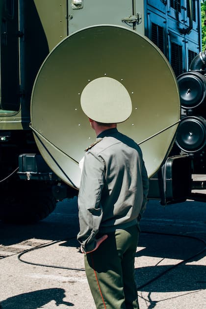 Un oficial bielorruso y una antena parabólica fijadas en un camión. MILEX Expo, Minsk, Bielorrusia, 2017