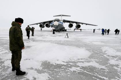 Un oficial ruso se encuentra cerca de un avión de carga militar Il-76 aterrizado en la isla Alexandra Land cerca de Nagurskoye, Rusia