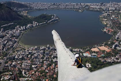 Un operario se asoma desde adentro del Cristo