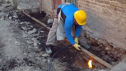 Un operario trabaja para remover una vía escondida bajo tierra