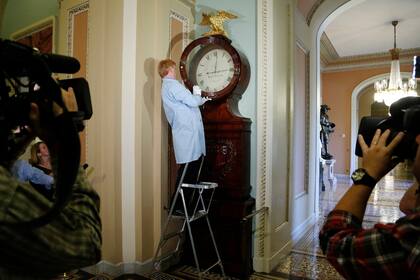 Un operario vuelve a dar cuerda al histórico reloj Ohio del Senado