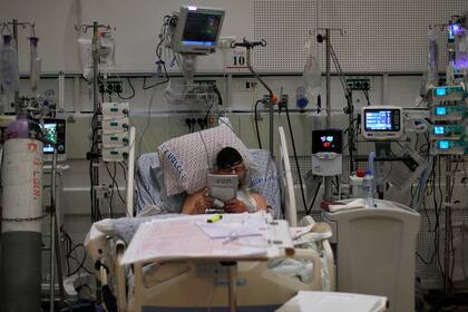 Un paciente de Covid-19 lee un libro en una sala de aislamiento de coronavirus en el Centro Médico Ziv en la ciudad de Safed, en el norte de Israel