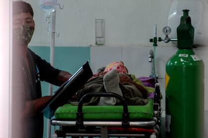 Un paciente es visto en una camilla junto a un trabajador de la salud y un cilindro de oxígeno en el hospital público de Manacapuru, estado de Amazonas, Brasil, el 20 de enero de 2021