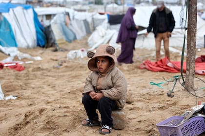 Un palestino observa mientras sus familiares reorganizan su carpa, un día después de que el ejército israelí bombardeara un campamento de tiendas que alojaba a familias desplazadas, en el campo de refugiados de Al-Shati, en Ciudad de Gaza