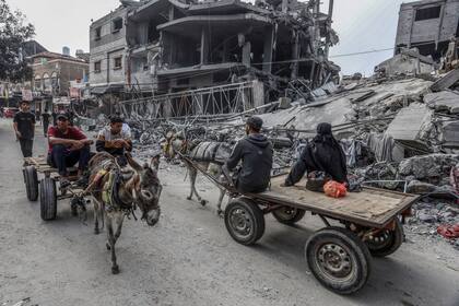 Un palestino pasa junto a un edificio destruido, en medio de las batallas en curso entre Israel y el grupo palestino Hamas