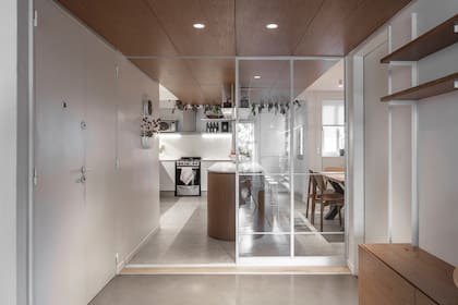 Un panel vidriado divide la cocina del hall sin perder luz ni amplitud.