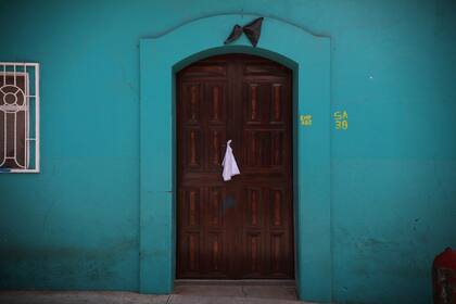 Un pañuelo blanco está atado a la manija de la puerta y un banderín negro en el marco de la puerta de una casa en la ciudad de Pantelho