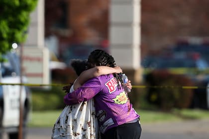 Un par de personas se abraza afuera del supermercado donde se registró un tiroteo el sábado 14 de mayo de 2022, en Buffalo, Nueva York. (AP Foto/Joshua Bessex)