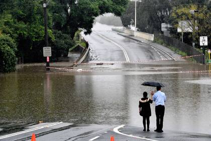 Un pareja observa el camino inundado en el área de Windsor en el noroeste de Sydney
