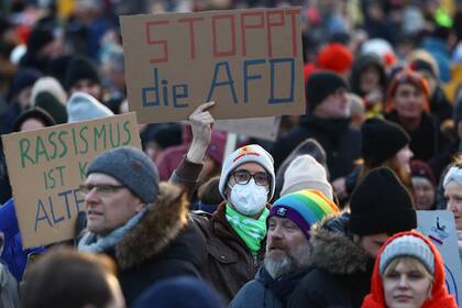 Un participante sostiene un cartel que dice "Stop AfD" durante una manifestación contra el racismo y la política de extrema derecha frente al edificio del Reichstag en Berlín, Alemania, el 21 de enero de 2024