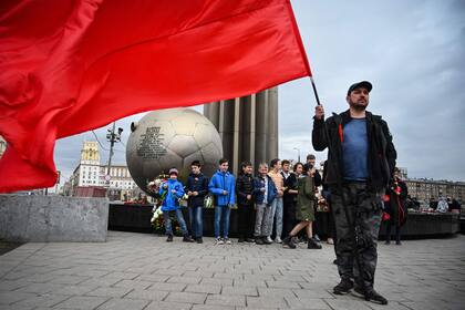 Un partidario comunista sostiene una bandera soviética frente al monumento al cosmonauta soviético Yuri Gagarin en Moscú