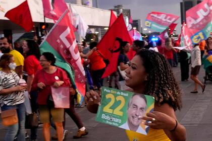 Un partidario corre con una calcomanía con la imagen del presidente de Brasil, Jair Bolsonaro, quien se postula para la reelección, durante un acto de campaña en la estación de autobuses de Brasilia, Brasil, el miércoles 26 de octubre de 2022